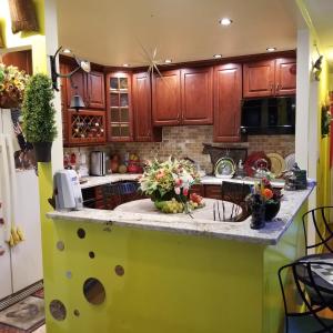 una cocina con armarios de madera y una encimera con flores. en Joy's Country Home en Brooklyn