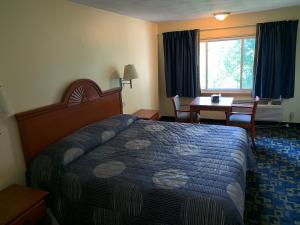 a hotel room with a bed and a table and a desk at Rumford Motor Inn in Rumford