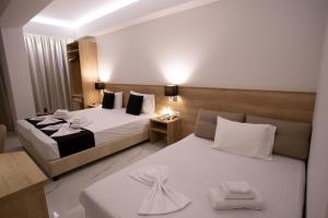 pokój hotelowy z 2 łóżkami i ręcznikami w obiekcie Marvel Deluxe Rooms w Heraklionie