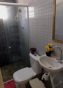 a bathroom with a toilet and a sink and a shower at Cantinho Da Del in Recife