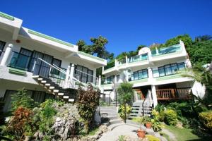 a house with a balcony overlooking a river at Turtle Inn Resort in Boracay