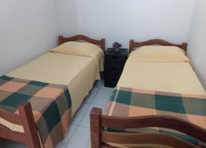 duas camas sentadas uma ao lado da outra num quarto em Cantinho Da Del no Recife