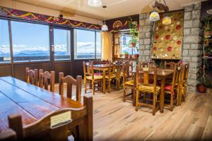 a restaurant with wooden tables and chairs and windows at Hospedaje Penthouse 1004 in San Carlos de Bariloche