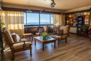 sala de estar con muebles y ventana grande en Hospedaje Penthouse 1004 en San Carlos de Bariloche