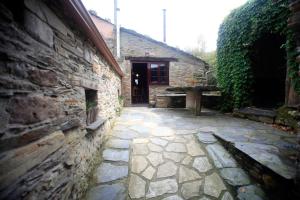 a stone walkway leading to a building with a door at Vivienda Vacacional Bioxana in Molejón