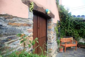 una porta in legno su un edificio con panca di legno di Vivienda Vacacional Bioxana a Molejón