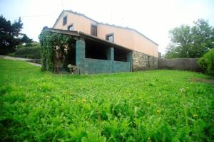 ein Haus mit einem Rasenplatz davor in der Unterkunft Vivienda Vacacional Bioxana in Molejón