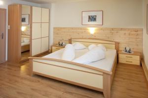 Un dormitorio con una cama grande con almohadas blancas. en Landhaus Gudrun, en Tux
