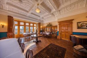 uma grande sala com mesas e cadeiras num edifício em Pen-y-bryn Lodge em Oamaru