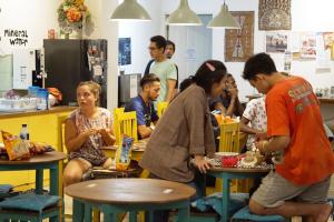 a group of people sitting at tables in a restaurant at Wonderloft Hostel in Jakarta