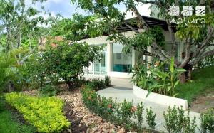 a garden in front of a house at Natura Reservado - Hoteles Natura in Anapoima