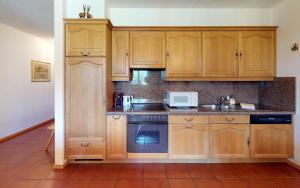 una cucina con armadi in legno, lavandino e forno a microonde di Ludains 6 a Sankt Moritz