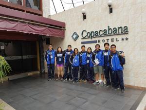 un grupo de personas de pie frente a un hotel en Copacabana Hotel, en Tacna