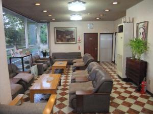 
a living room filled with furniture and a tv at Hotel New Takahashi Takezono in Tsukuba
