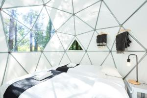 1 dormitorio con 1 cama en una habitación con paredes de cristal en 泊まれる公園 INN THE PARK, en Numazu