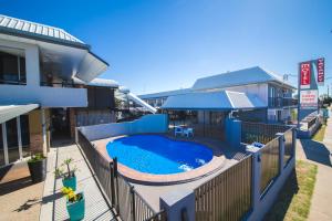 
a blue and white swimming pool next to a building at Metro Motel Rockhampton in Rockhampton
