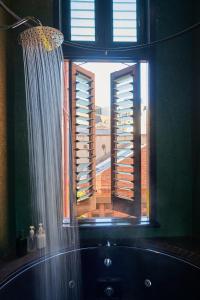 baño con ventana con bañera y cortina de ducha en Central City Warehouse Apartment en Melbourne