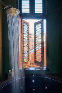 a bathroom with a window with a tub and a shower curtain at Central City Warehouse Apartment in Melbourne