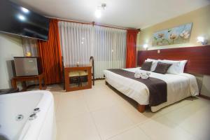 1 dormitorio con cama, bañera y TV en Hotel La Casona Del Olivo Arequipa en Arequipa