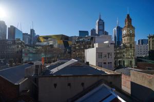 een uitzicht op de skyline van de stad met een klokkentoren bij Central City Warehouse Apartment in Melbourne +4 foto's