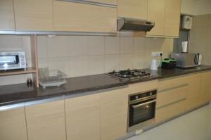 a kitchen with a stove and a microwave at Atrium - ICONIC APARTMENT in Sri Jayewardenepura Kotte
