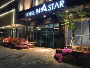 a hotel in a star with purple flowers in front of it at Instar Tourist Hotel in Daegu