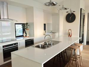 a white kitchen with a sink and a counter at Scandinavian Cabin - Maleny - One Bedroom in Maleny