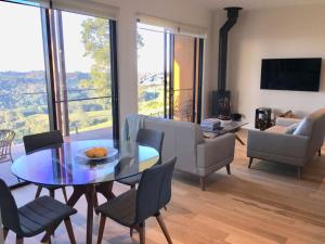 a living room with a glass table and chairs at Scandinavian Cabin - Maleny - One Bedroom in Maleny