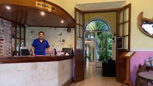 a man standing at the counter of a restaurant at Hotel Santa Ana in Mérida