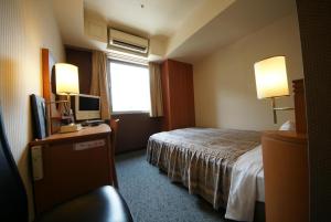 a hotel room with a bed and a window at Hotel Landmark Nagoya in Nagoya