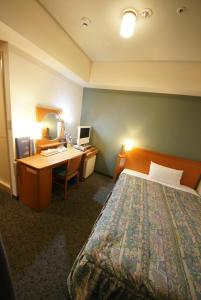 a hotel room with a bed and a desk with a computer at Hotel Landmark Nagoya in Nagoya