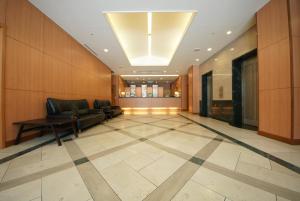 a lobby with a couch and chairs on a tiled floor at Hotel Landmark Nagoya in Nagoya