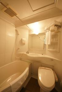 a bathroom with a tub and a toilet and a sink at Hotel Landmark Nagoya in Nagoya