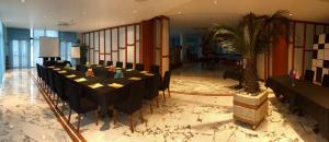 a group of tables in a room with a palm tree at Best Western Hotel Nettuno in Brindisi
