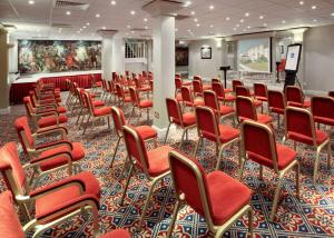 a conference room with red chairs and a podium at Grosvenor Hotel in Stratford-upon-Avon