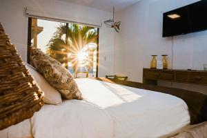 a bedroom with a large white bed with a window at Hotel Vistalmar in Manta