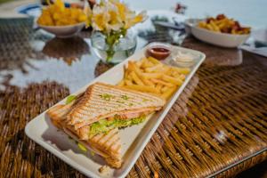 a sandwich and french fries on a plate on a table at Hotel Vistalmar in Manta