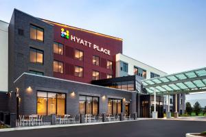 a hotel with tables and chairs in front of a building at Hyatt Place Poughkeepsie - Hudson Valley in Poughkeepsie