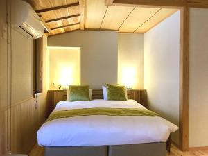 Un pat sau paturi într-o cameră la Kyomachiya Ryokan Sakura Urushitei