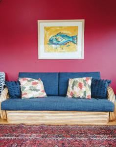 um sofá azul com almofadas numa sala de estar em Shelly Beach Studio, Waiheke Island em Auckland