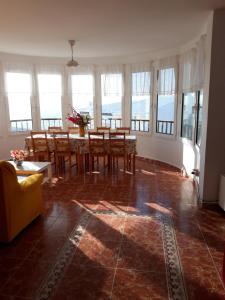 una sala da pranzo con tavolo, sedie e finestre di Rocamar 2 a Cala Morell