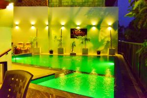 a swimming pool with green lights in a house at Thilaka City Hotel in Anuradhapura