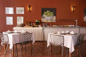 uma sala de jantar com duas mesas com toalha de mesa branca em Paradise Hotel Corfu em Gouviá