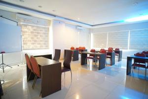 a conference room with tables and chairs and a screen at OYO 1477 Athar 88 Hotel in Balikpapan