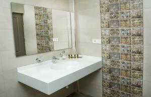 bagno con lavandino bianco e specchio di Teryan Pushkin Apart Hotel a Yerevan