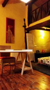a table and a chair in a room with a bed at La Casa Amarilla in Olleros de Pisuerga