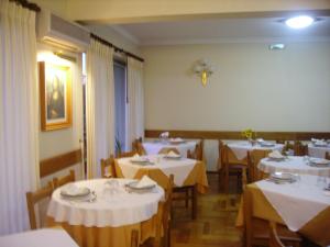 ein Esszimmer mit weißen Tischen und Stühlen in der Unterkunft Hotel Peninsular in Caldelas
