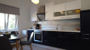 a kitchen with white cabinets and a table and a sink at Blue Sky in Frangokastello