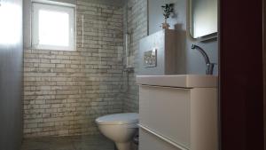 a bathroom with a toilet and a sink and a window at Blue Sky in Frangokastello