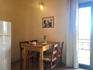 a dining room table with chairs and a refrigerator at Blue Sky in Frangokastello